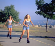 two girls rollerblading near the beach