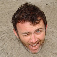 Tommy Tiernan buried in the sand