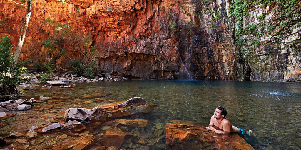 Man lounging in gorge pool