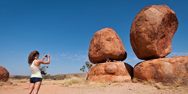 girl taking photos of the Devils Marbles