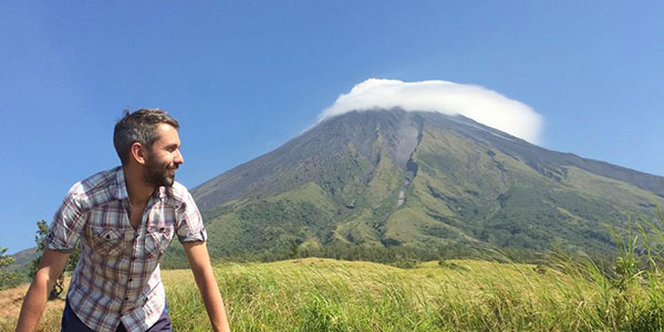 alex-wallace-Quadbiking-at-Mount-Mayon,-Legazpi,-Philippines traveller standing in front of volcano in the philippines