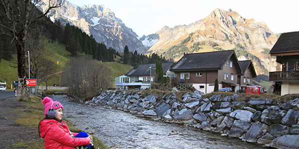 alicia-boey-swiss girl sitting in swiss village with mountains in background