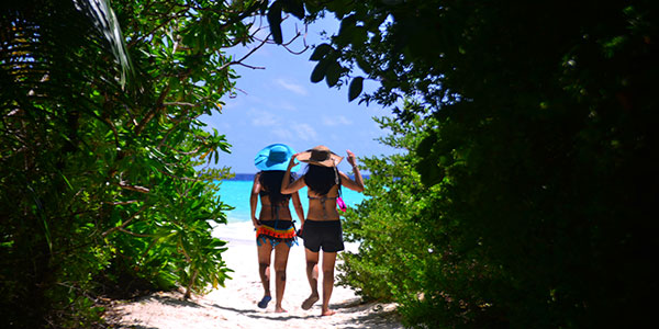 secret-paradise-the-maldives girls walking to the beach in the maldives