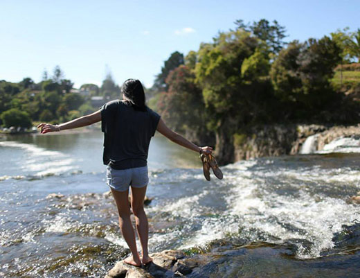 girl standing in a river in new zealand