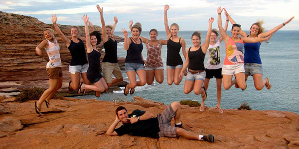 tour group jumping by the coast