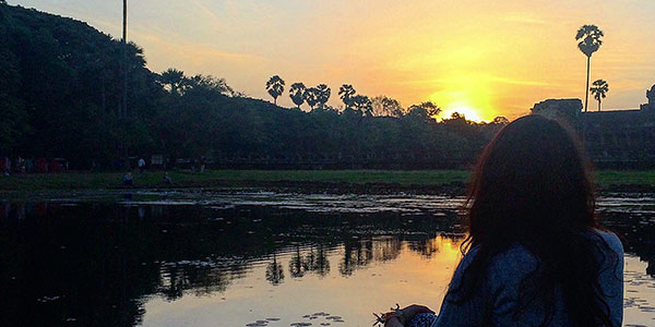 contiki-asian-adventure-sunset girl watching the sunset by a lake in Cambodia