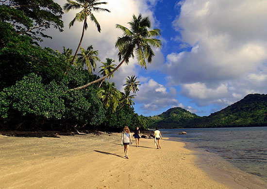 people walking on a beach in fiji