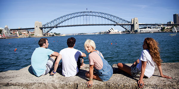 friends sitting in front of sydney harbour bridge