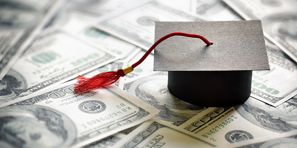 student-loan-graduation-cap graduation cap on dollar notes