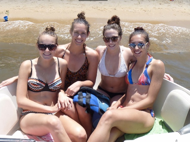 four girls in bikinis on a boat